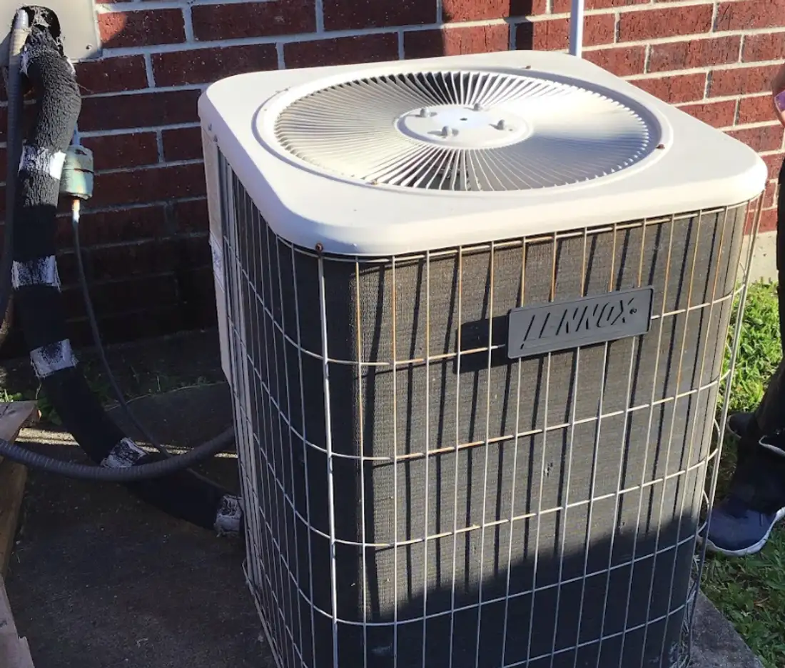 Condenser unit beside a brick Cypress home during a service call